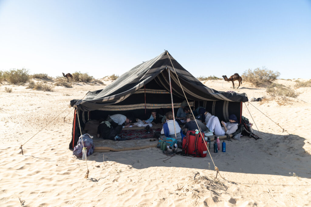 Une tente où sont assis les participants, ils se détendent