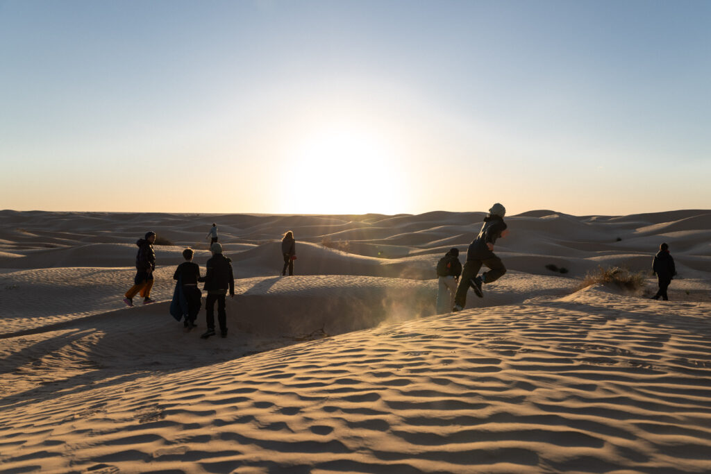 Jeunes courant dans les dunes, au coucher du soleil