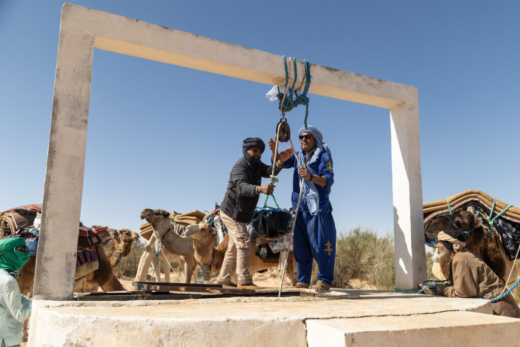Deux chamelier qui tirent de l'eau au puit dans le désert